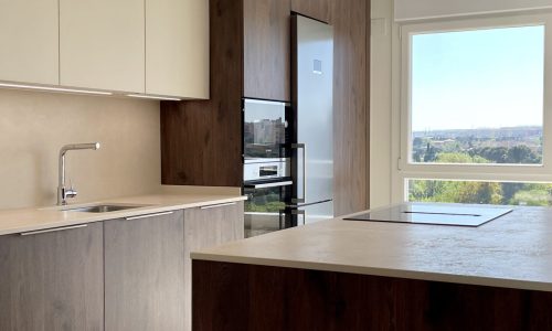 Cocina con isla de madera oscura y vistas