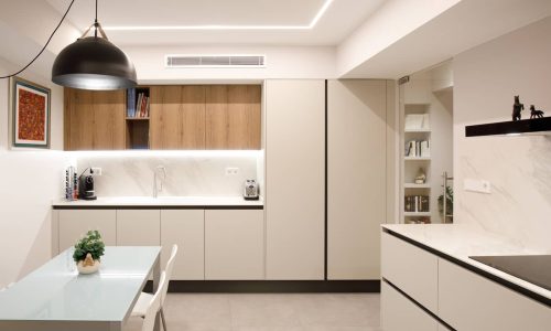 Cocina reformada con mesa de office y lámpara negra