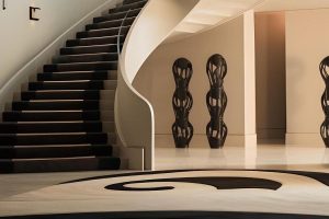 entrada elegante con escalera curva y arte moderno en paredes espacio amplio luminoso decoracion minimalista y acogedora