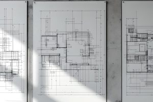 planos de arquitectura en exposicion en una pared