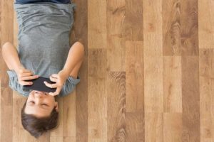 nino jugando con una consola tumbado en el suelo