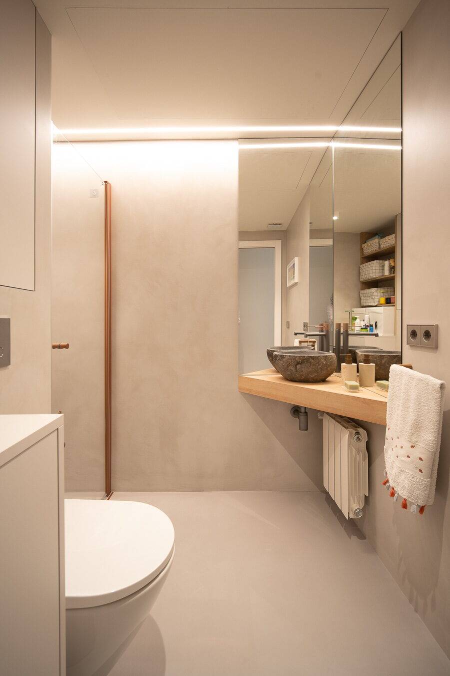 Baño con acabados continuos y ducha a ras de suelo (IP06)